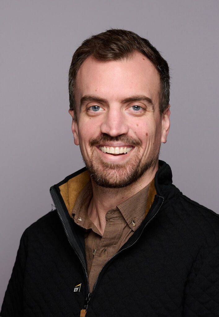 A man with a beard and mustache wearing a jacket